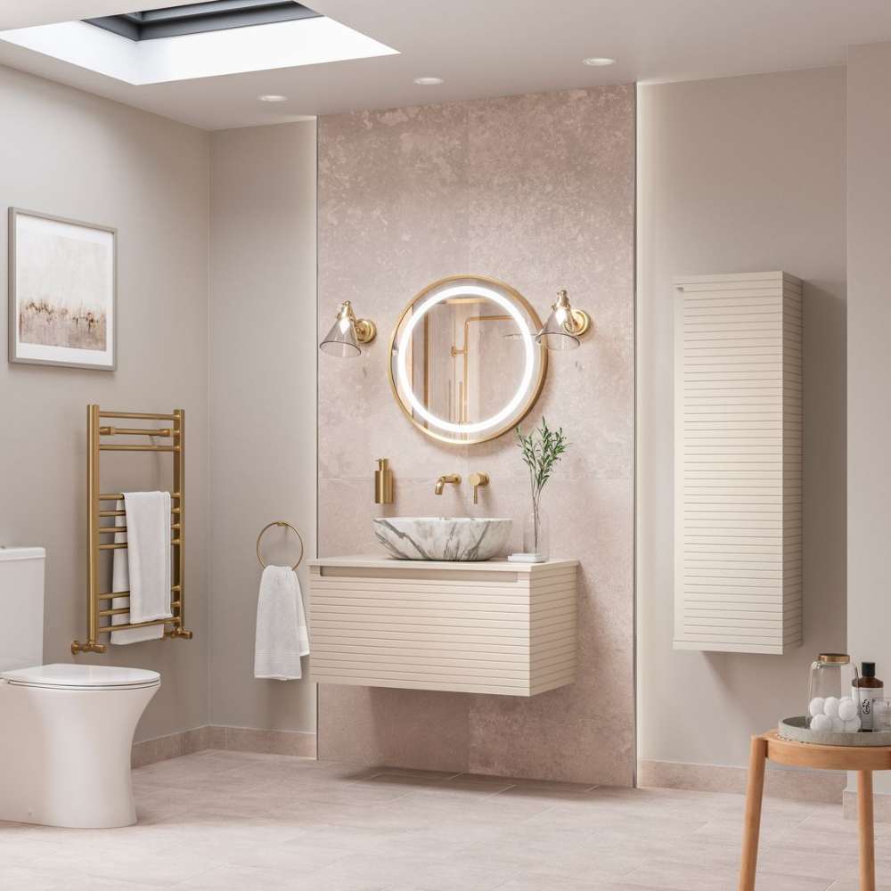 Bathroom with beige tones, round backlit mirror, marble sink, gold fixtures, and skylight, serene and luxurious.